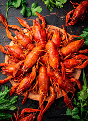 Boiled crayfish on a wooden cutting board with parsley. 