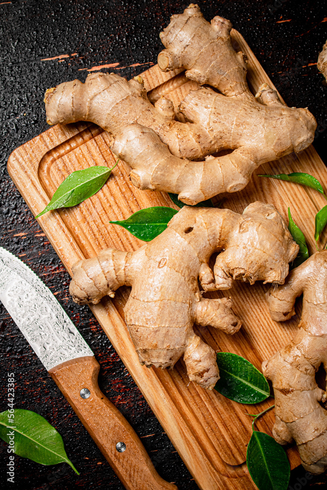 Poster ginger on a cutting board with a knife.