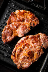Flavorful grilled pork steak in a frying pan.
