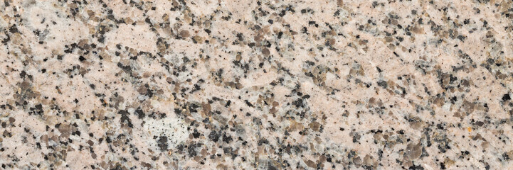 Granite texture. Natural granite with a grainy pattern. Stone background. Solid rough surface of rock. Durable construction and decoration material. Close-up.