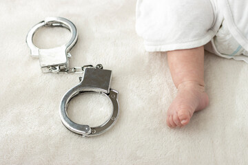 赤ちゃんの足と玩具の手錠（0歳1か月、日本人、男の子）