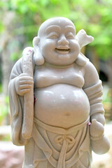 Fototapeta na wymiar White stone statue of the Sangkachai Buddha Arhat of Abundance - Chinese Buddhism