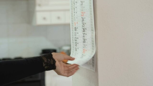 Wife woman use paper calendar for date planning at home, organize important events and appointments