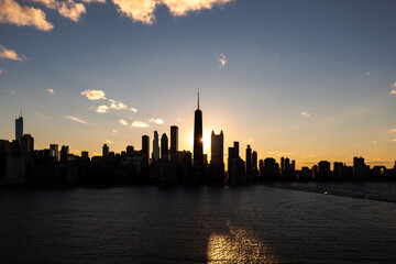 Beautiful downtown Chicago skyline aerial over Lake Michigan during the Chicago henge or autumn equinox as the golden colored sun aligns with the streets between high-rise buildings.