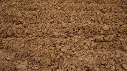 Closeup of macro view of red dirt or mud of pile soil from agriculture land. Soil Background.