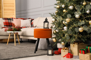 Beautiful Christmas tree, gift boxes and sofa in living room