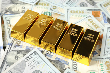 Many shiny gold bars on dollar banknotes