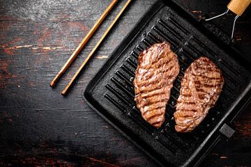 Aromatic grilled steak in a frying pan. 