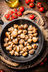 Obraz na płótnie Canvas Frying pan with fried mushrooms on a wooden tray. 