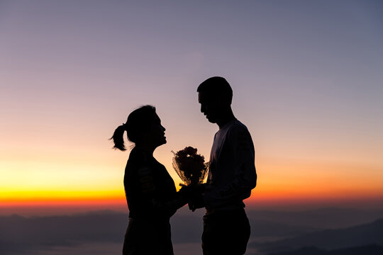 Silhouette of wedding Couple in love during sunrise with morning sky background. Pre-wedding portraits happy couple images man and woman with sky nature background. valentines day concept.