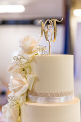 Beautiful white wedding cake decorated with roses close up