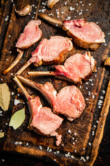 Rack grilled lamb on a cutting board with bay leaves. 