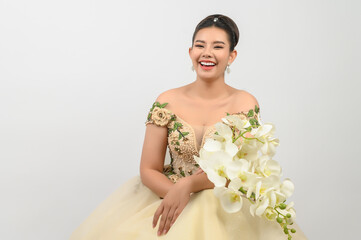 Young asian beautiful bride with orchid bouquet on white background