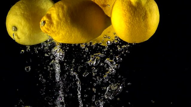 Super slow motion of falling lemon into splashing water. Lemonade cooking concept. Filmed on high speed cinema camera, 4k 1000 fps.