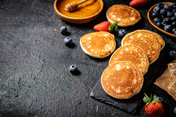 Pancakes on a stone board with fresh berries. 
