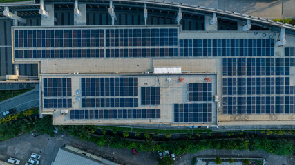 Top view of blue solar photo voltaic panels system on high apartment building roof top on sunny day. Renewable ecological green energy production concept.