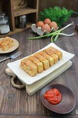 omelette serving on a white tray with fresh eggs in the background