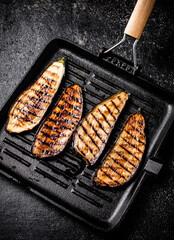 Slices of eggplant in a grill pan. 