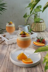 orange pudding in a glass garnished with sliced ​​oranges and strawberries