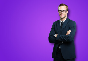 Obraz na płótnie Canvas Portrait of businessman in eye glasses, spectacles, black suit and tie, with crossed arms, on violet purple background. Business concept. Smiling man at studio picture. Copy space for ad.