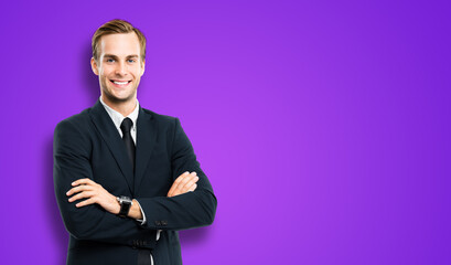 Obraz na płótnie Canvas Portrait of businessman in black suit, with folded arms, on violet purple background. Smiling business man at studio picture. Copy space for text.
