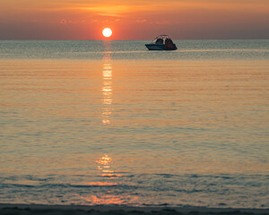 Colorful sky and the sea at dawn. The rising sun is in the background