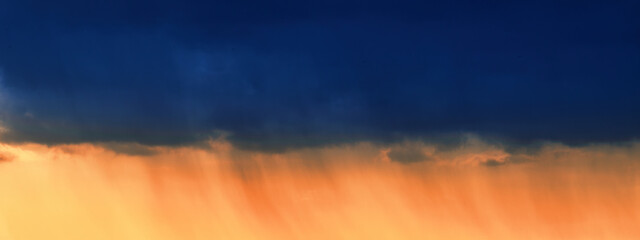 Summer sunset. Storm clouds on the background of the orange sky.