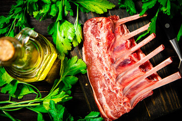 Raw rack of lamb on a parsley cutting board. 