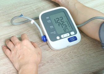 Man check blood pressure monitor and heart rate monitor with digital pressure gauge. Health care and Medical concept.