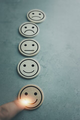 Hand of a man chooses a smiley face icon on wood block cube, The best excellent business services...