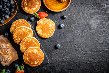 Pancakes on a stone board with fresh berries. 