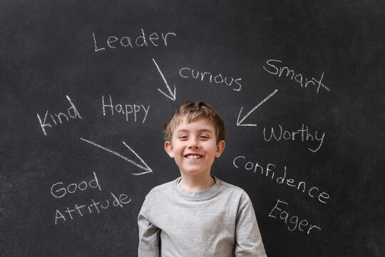 Positive encouraging words written on a blackboard with a happy smiling child