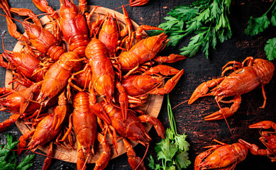Boiled crayfish on a wooden cutting board with parsley. 