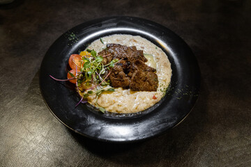 a bowl of risotto topped with meat