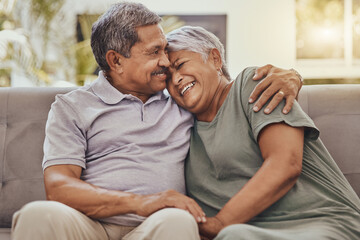 Happy, love and senior couple on a sofa hugging, bonding and relaxing together in their living room. Happiness, laugh and elderly man and woman pensioners in retirement embracing on a couch at home.