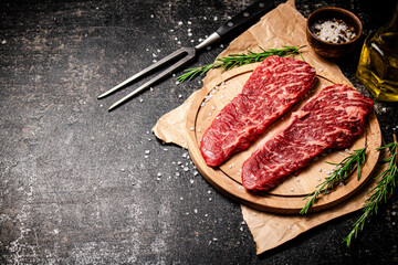 Raw steak on a wooden cutting board. 