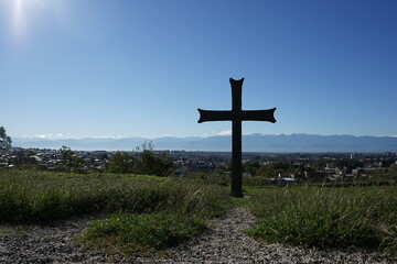 Fototapeta na wymiar Christian cross on the ground with beautiful town background