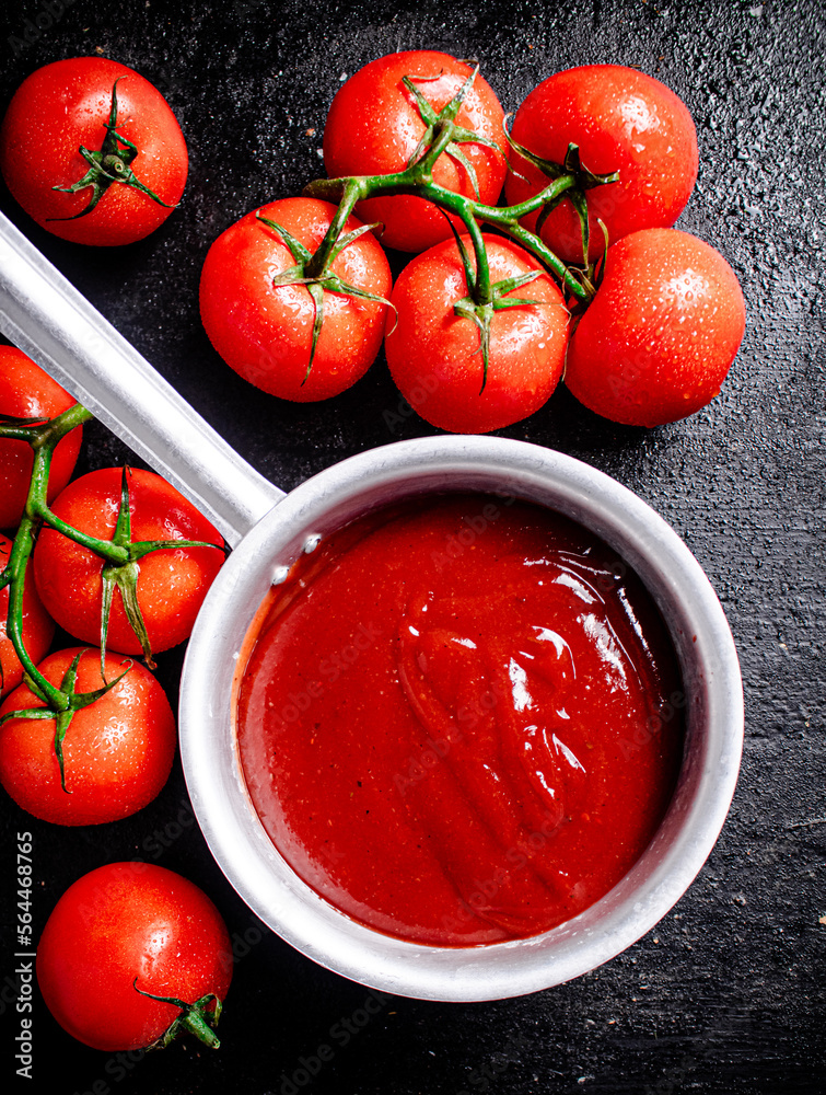 Wall mural Tomato sauce with ripe fresh tomatoes on a branch. 