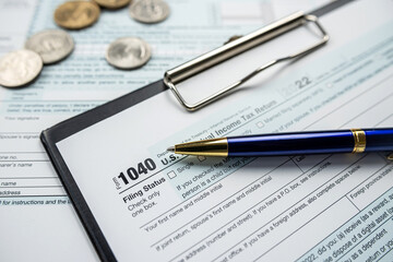 Concept of filling in 1040 tax return form with pen