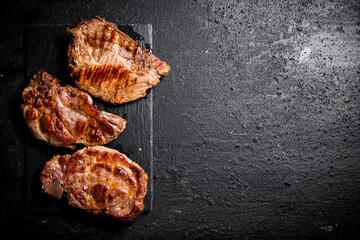 Delicious grilled pork steak on a stone board. 
