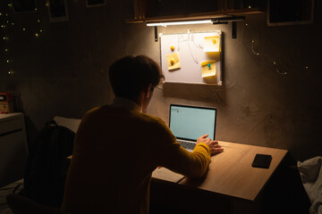 Arabic university student in dorm working on laptop at the late night.