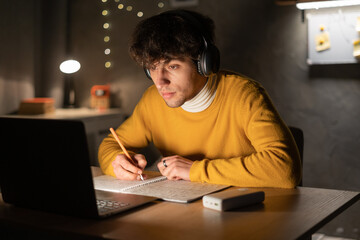 Arab guy student use the laptop in the evening.