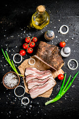 Pieces of lard on paper with onions and tomatoes. 