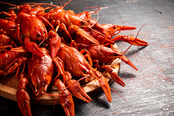 Boiled crayfish on a round cutting board. 