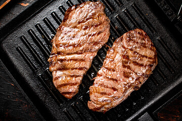 Aromatic grilled steak in a frying pan. 