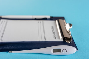 Pharmaceutical RX prescription form with thermometer on blue background