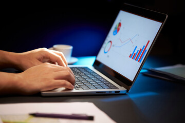 businessman working late at night using laptop. making analyst report and typing 