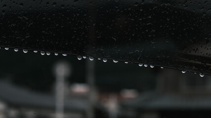  車内から見る雨に濡れて水滴がついた車のガラス