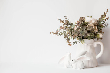 A beautiful postcard. Banner. The concept of a bright Easter holiday. Bouquet of flowers, white rabbits and Easter eggs on a white isolated background.