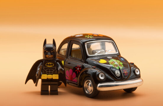 Bologna - Italy - January 47, 2023: Lego Batman ready for driving a vintage Volkswagen Beetle painted in Hippie lifestyle.